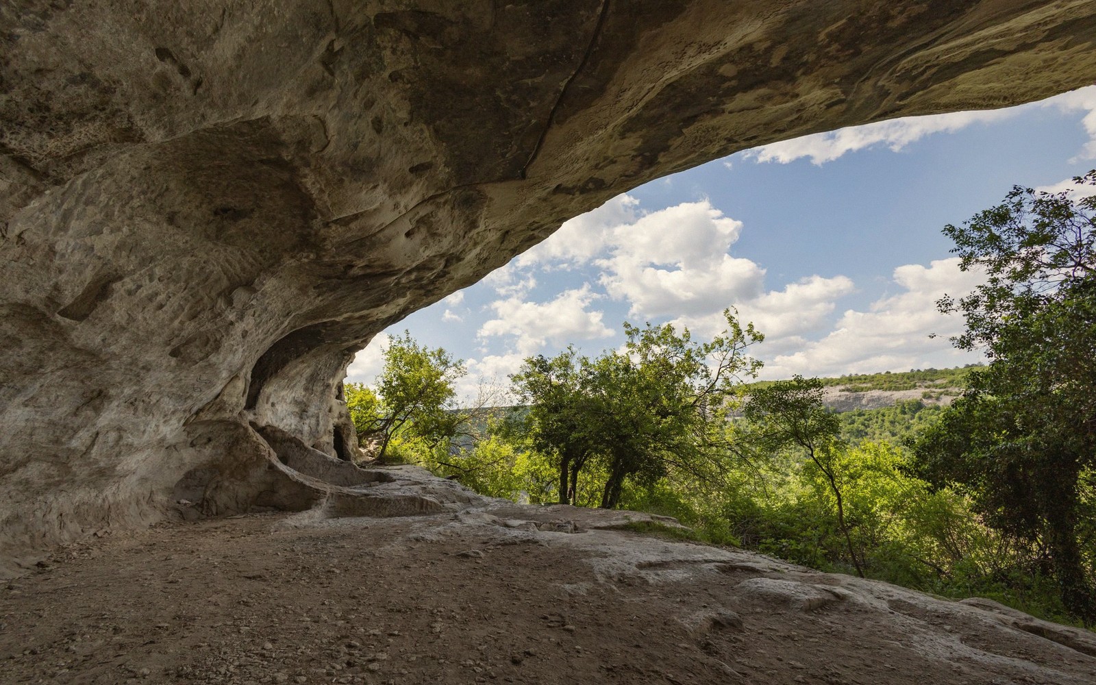 a limestone natural arch over a creek, seen from downstream